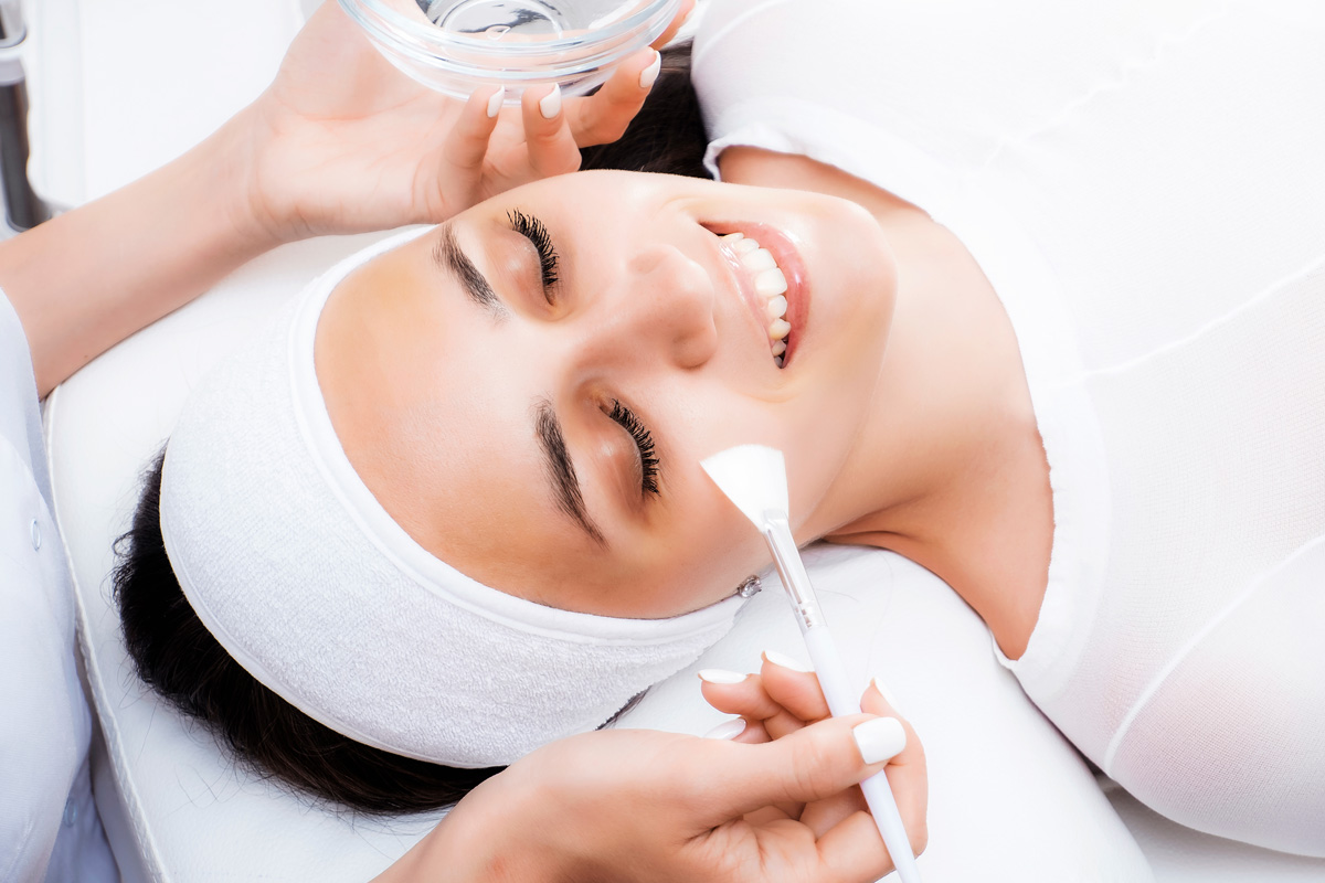 A smiling woman getting a chemical peel at a med spa in Richmond.