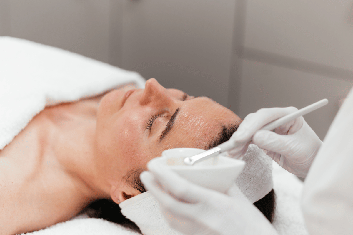 An esthetician applying a chemical peel on a patient